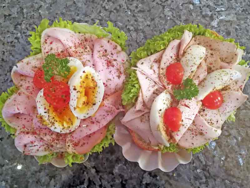 Auswahl an frisch belegten und bunt garnierten Party-Brötchen